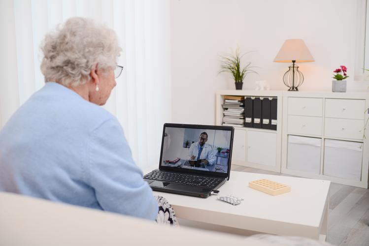 Ältere Dame am Computer in einem Online Termin mit Berater