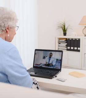 Ältere Dame am Computer in einem Online Termin mit Berater